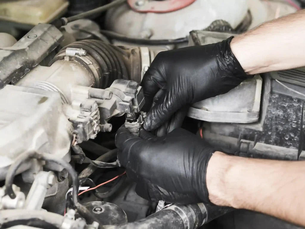 A imagem mostra uma pessoa realizando manutenção em um motor de veículo, destacando a importância do conhecimento técnico em autopeças. No contexto do artigo, isso reflete a necessidade de especialização e competência para montar um e-commerce de autopeças, abrangendo desde o conhecimento dos produtos até a capacidade de fornecer informações precisas e soluções para os clientes.
