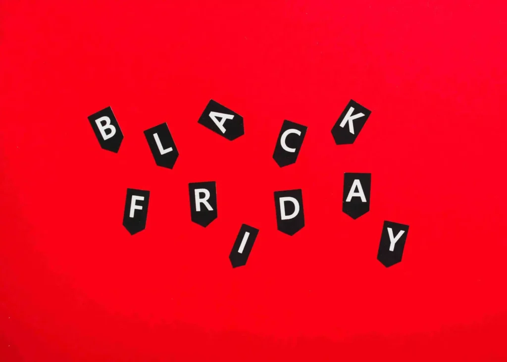 A imagem destaca a Black Friday com letras em formigas espalhadas em um fundo vermelho, representando a importância desse evento para o comércio eletrônico. O artigo menciona que a empresa ONCLICK relata um aumento de 300% no e-commerce de seus clientes, sugerindo que a Black Friday pode ser lucrativa fora de sua data tradicional, impulsionando vendas e crescimento nos negócios online.