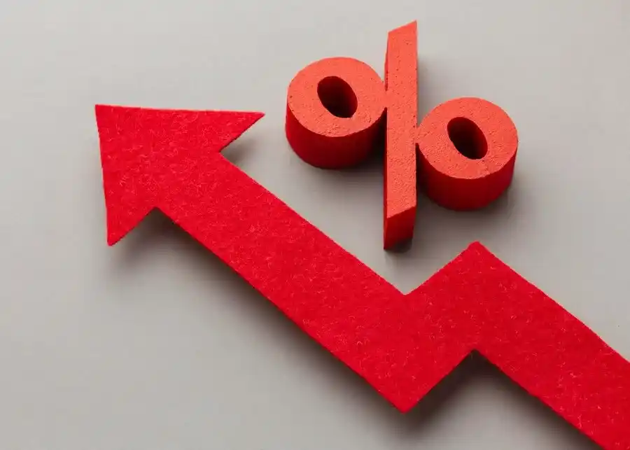 A imagem apresenta um símbolo de seta vermelha apontando para baixo, seguido de dois círculos que representam o símbolo percentual (%). Essa representação gráfica é frequentemente usada para indicar uma queda ou redução de preços, o que é diretamente relacionado ao contexto da Black Friday. O artigo "Guia rápido com 6 estratégias que funcionam na Black Friday" provavelmente discute como as empresas podem utilizar promoções, marketing e outras tácticas para atrair consumidores e aumentar as vendas durante essa temporada de compras. A imagem simboliza a estratégia de oferecer descontos agressivos, que é um componente chave dessas promoções.