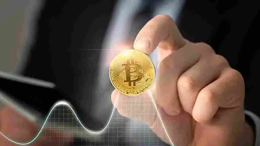 A imagem destaca a relevância do Bitcoin no varejo, com uma mão segurando uma moeda de Bitcoin, simbolizando o crescente interesse e adoção de criptomoedas como meio de pagamento. O contexto sugere que os varejistas devem estar atentos ao potencial do Bitcoin para transformar transações comerciais, oferecendo mais facilidade e segurança financeira aos consumidores.