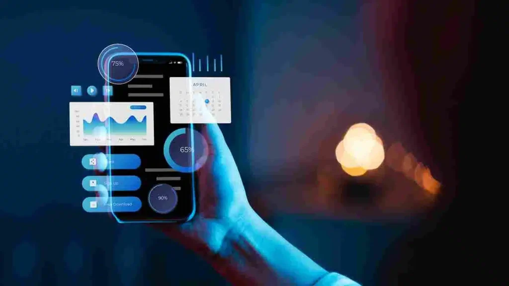 A imagem mostra uma mão segurando um smartphone com diversos elementos gráficos na tela, como gráficos, porcentagens e um calendário. Isso sugere que o conteúdo está relacionado a aspectos da transformação digital e sua importância para os negócios. A imagem parece estar associada a um artigo sobre os benefícios e a necessidade de adaptar os negócios à transformação digital, com foco em dados, métricas e informações relevantes para esse contexto.
