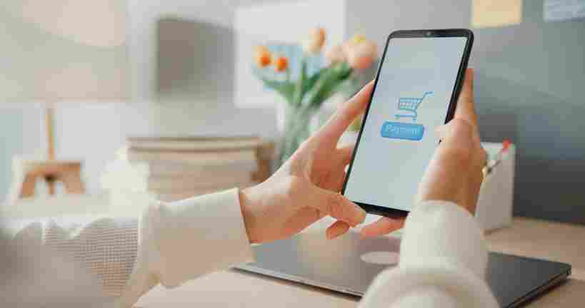 Pessoa utilizando smartphone com carrinho de compras online, representando força de vendas no e-commerce, gestão de loja virtual, experiência do usuário e estratégias de conversão digital.