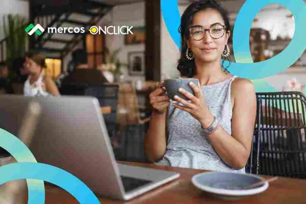 Duas pessoas trabalhando em frente a notebooks em uma mesa de escritório moderna, em uma discussão colaborativa. A tela do notebook da esquerda mostra dados e gráficos de desempenho, representando a interface do sistema Mercos B2B para gestão de vendas. A imagem simboliza a tomada de decisão baseada em dados reais de SLA por região e conciliação e margem para distribuidores e indústrias que buscam automação de processos.